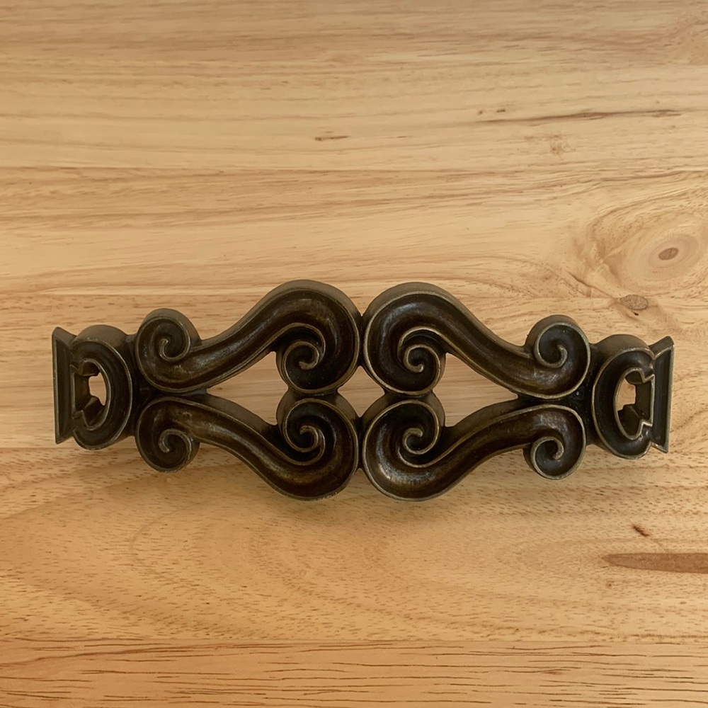 Maximalist drawer pull hardware. Made out of metal and has a bronze/ brass look.